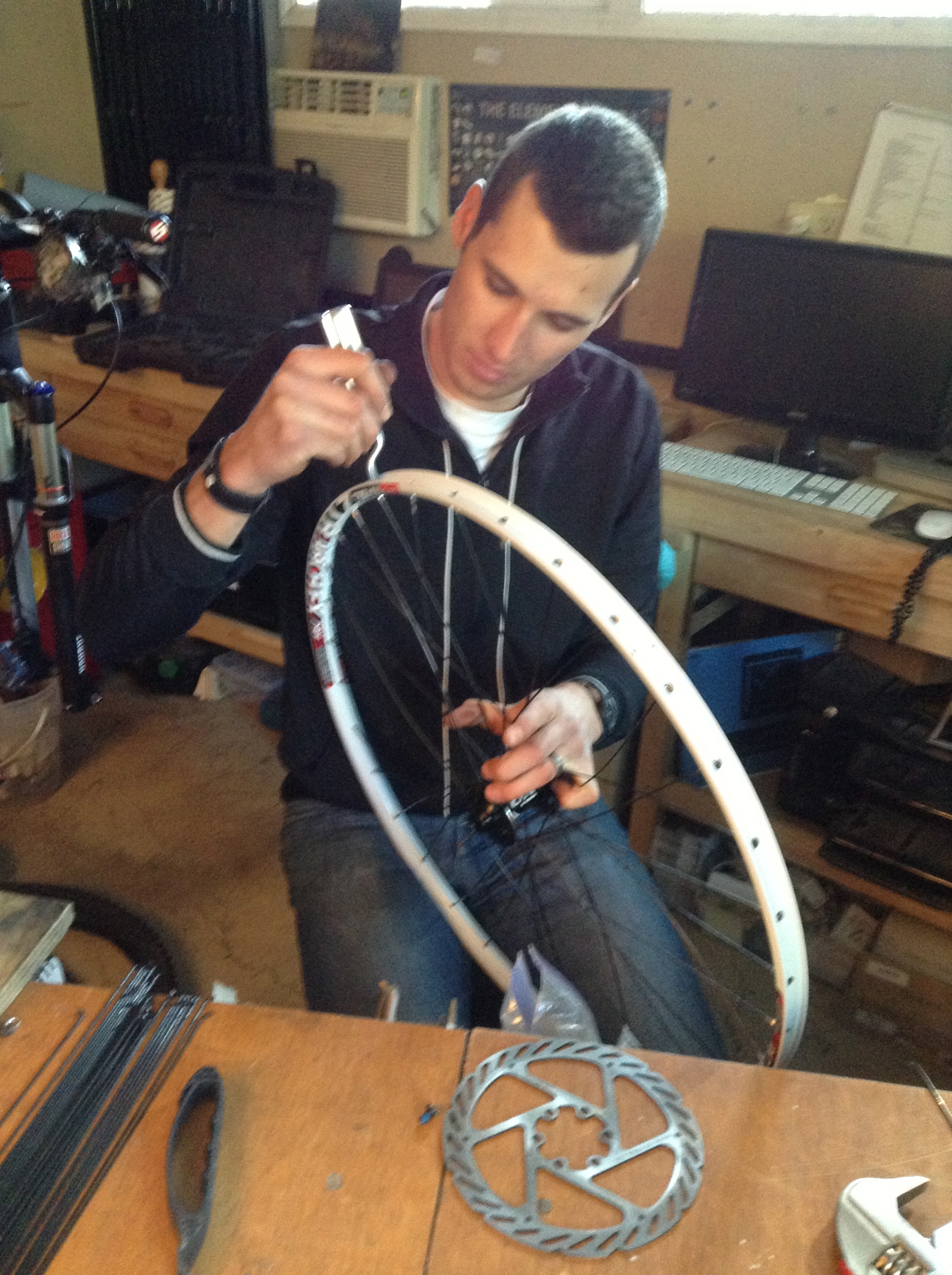 Ryan building a wheelset with white Stan's rims for Rhonda.